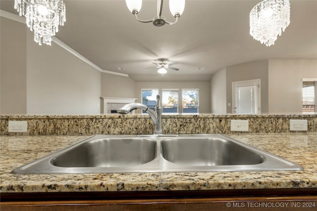 interior details featuring ornamental molding, sink, and hanging light fixtures