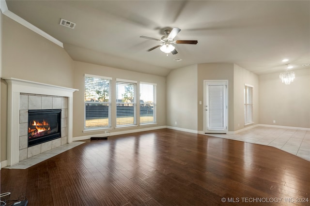 unfurnished living room featuring light hardwood / wood-style flooring, ceiling fan with notable chandelier, and a tile fireplace