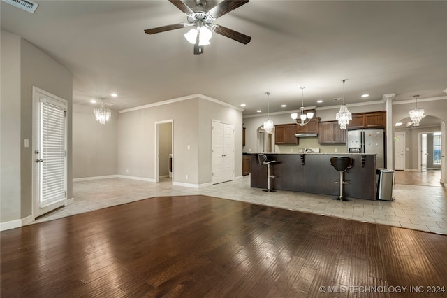 unfurnished living room featuring crown molding, light wood-type flooring, and ceiling fan