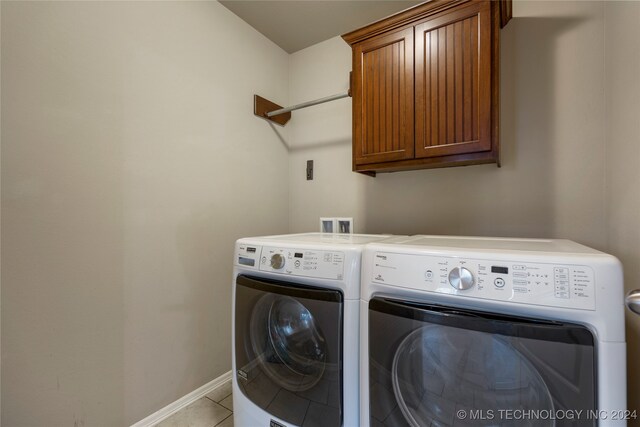 laundry room featuring cabinets, independent washer and dryer, and light tile patterned flooring