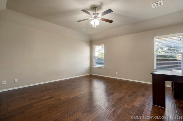 spare room with dark wood-type flooring, vaulted ceiling, and ceiling fan