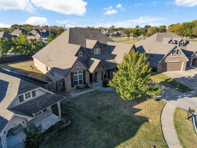 15410 E 87th St, Owasso, OK 74055 - view of front of house with stone siding, a residential view, concrete driveway, and a front lawn