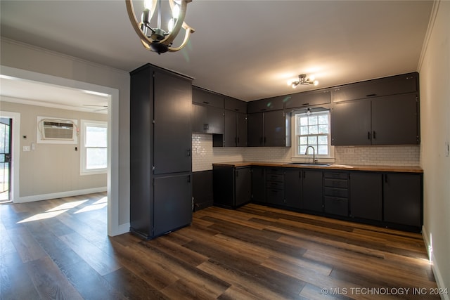 kitchen featuring sink, an AC wall unit, dark hardwood / wood-style flooring, and plenty of natural light