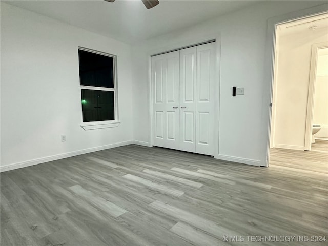 unfurnished bedroom with a closet, light hardwood / wood-style floors, and ceiling fan