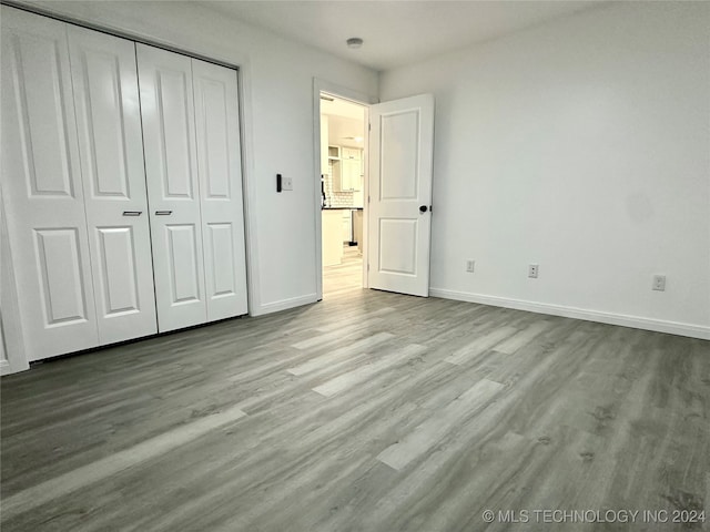 unfurnished bedroom with light hardwood / wood-style floors and a closet