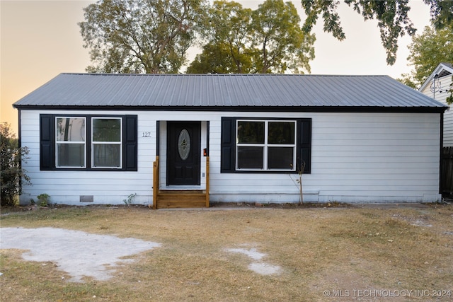 single story home featuring a yard