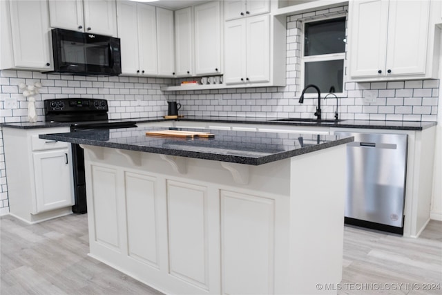 kitchen with black appliances, light wood-type flooring, and a kitchen island