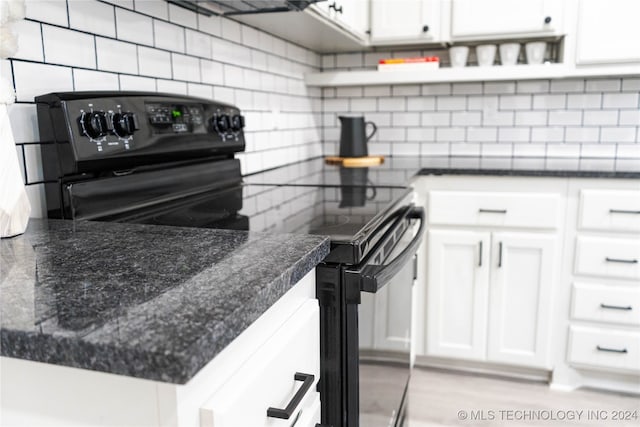 kitchen with decorative backsplash, white cabinets, and black / electric stove