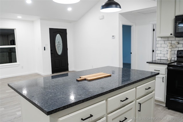 kitchen with light hardwood / wood-style flooring, black appliances, a center island, white cabinets, and tasteful backsplash