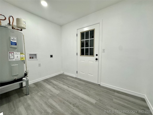 laundry area featuring water heater, electric dryer hookup, washer hookup, and light wood-type flooring