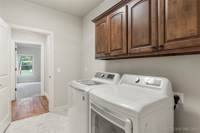 washroom featuring cabinets and washing machine and dryer