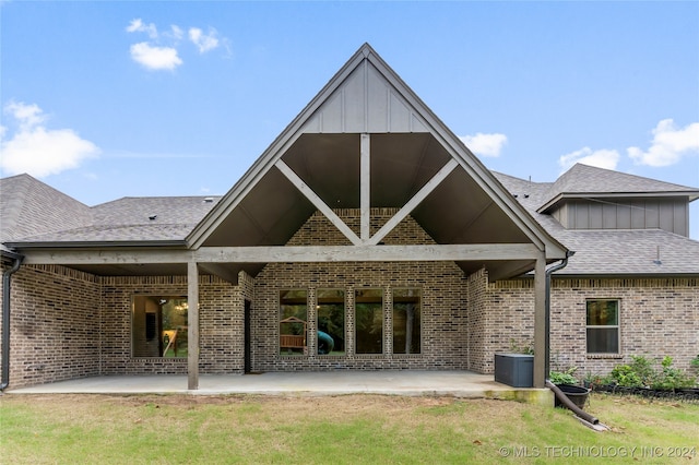 rear view of house with a patio and a lawn