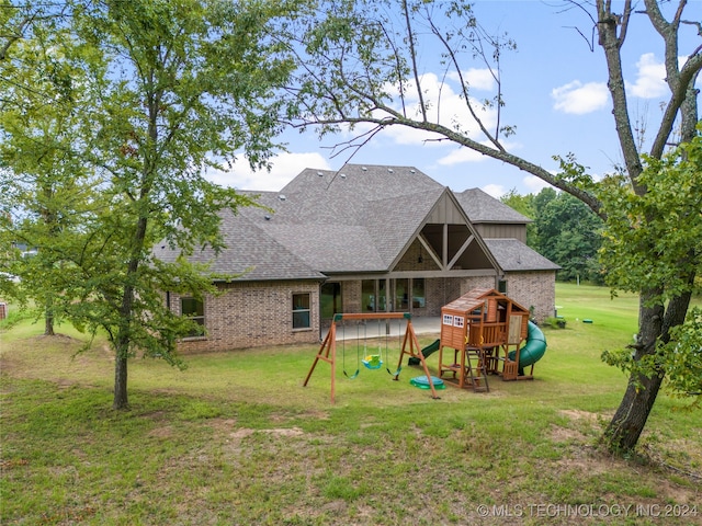 back of house with a yard and a playground