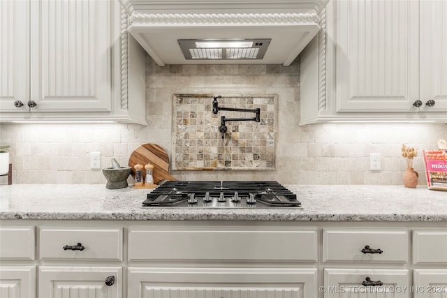 kitchen featuring white cabinetry, light stone counters, and stainless steel gas stovetop