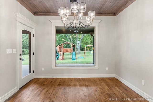 unfurnished dining area with hardwood / wood-style flooring, a healthy amount of sunlight, and an inviting chandelier