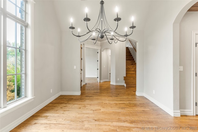 unfurnished dining area featuring light hardwood / wood-style floors and lofted ceiling