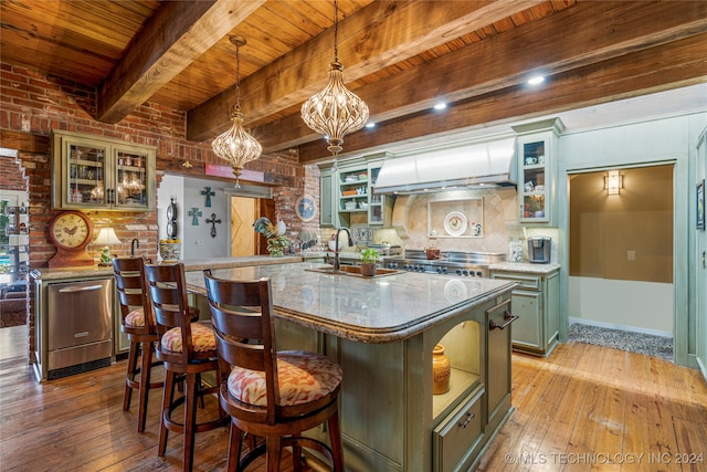 kitchen featuring sink, light hardwood / wood-style floors, wooden ceiling, pendant lighting, and a kitchen island with sink