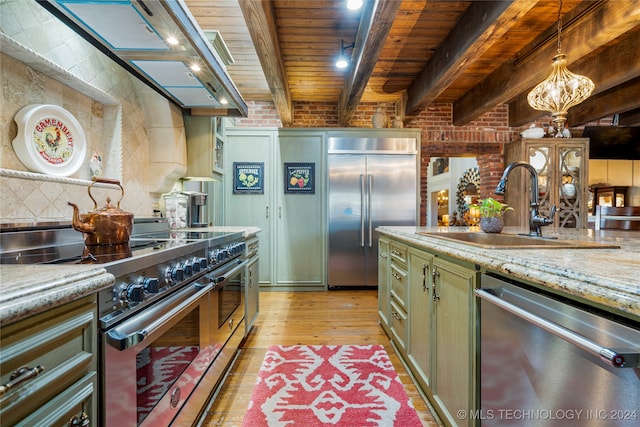 kitchen with beam ceiling, high quality appliances, green cabinets, pendant lighting, and light wood-type flooring