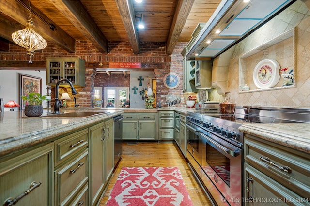 kitchen with light stone counters, appliances with stainless steel finishes, light wood-type flooring, sink, and green cabinetry