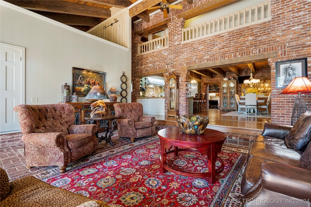 living room with decorative columns, a high ceiling, beam ceiling, a notable chandelier, and brick wall