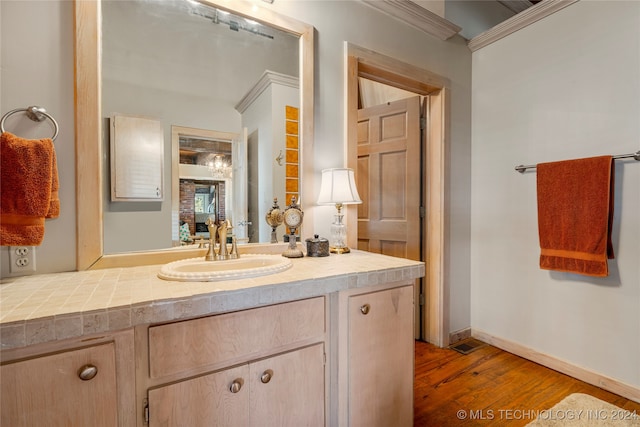 bathroom with vanity, crown molding, and hardwood / wood-style floors