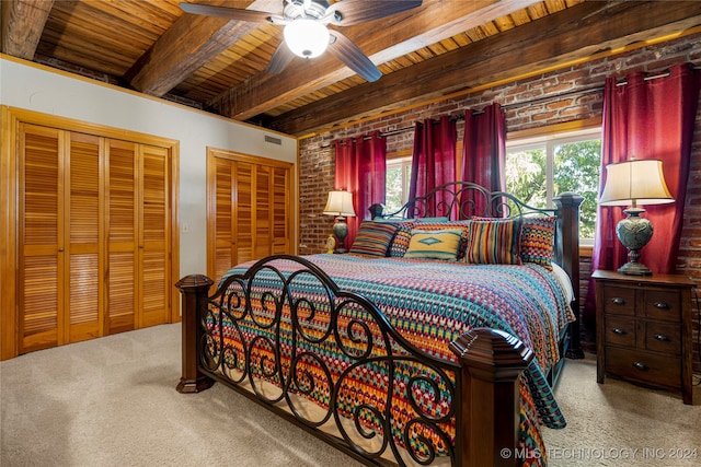 carpeted bedroom with beamed ceiling, wooden ceiling, brick wall, and ceiling fan