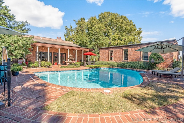 view of swimming pool with a patio and a yard