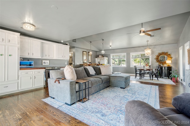 living room featuring vaulted ceiling, dark hardwood / wood-style floors, and ceiling fan