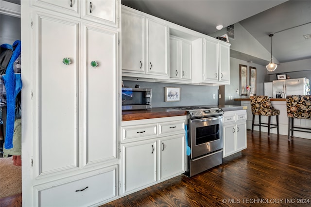 kitchen with dark hardwood / wood-style flooring, stainless steel appliances, vaulted ceiling, pendant lighting, and white cabinets