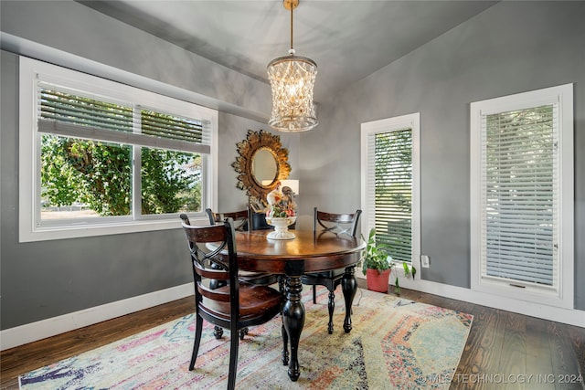 dining room featuring a chandelier, vaulted ceiling, and dark hardwood / wood-style flooring