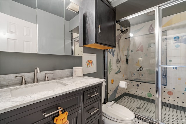 bathroom with a shower with door, vanity, and toilet