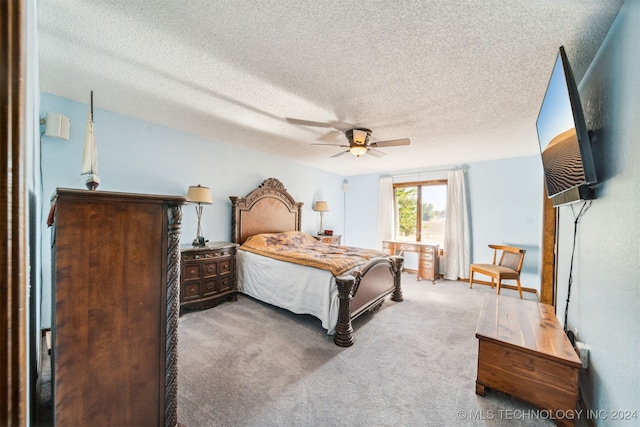 carpeted bedroom with ceiling fan and a textured ceiling