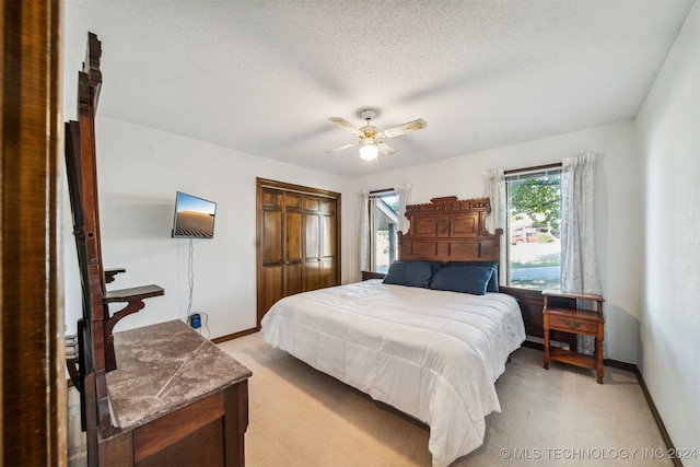 carpeted bedroom featuring ceiling fan, a textured ceiling, and a closet