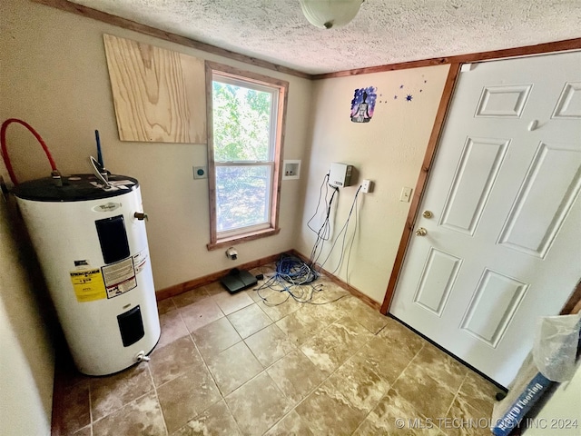 washroom featuring crown molding, electric water heater, a textured ceiling, and hookup for a washing machine