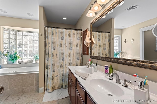 bathroom featuring vanity, tiled bath, and tile patterned flooring