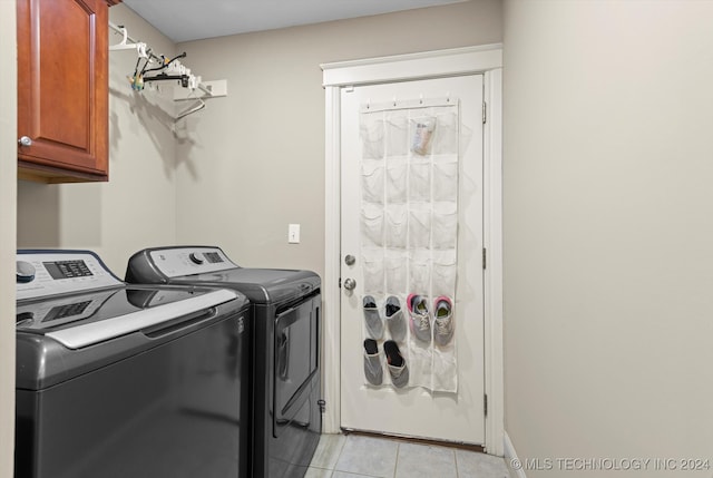 laundry area with cabinets, washing machine and dryer, and light tile patterned floors