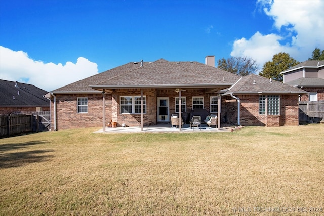 rear view of property with a patio and a lawn