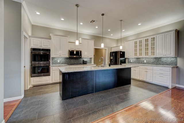 kitchen with white cabinets, a center island with sink, hanging light fixtures, dark hardwood / wood-style flooring, and black appliances