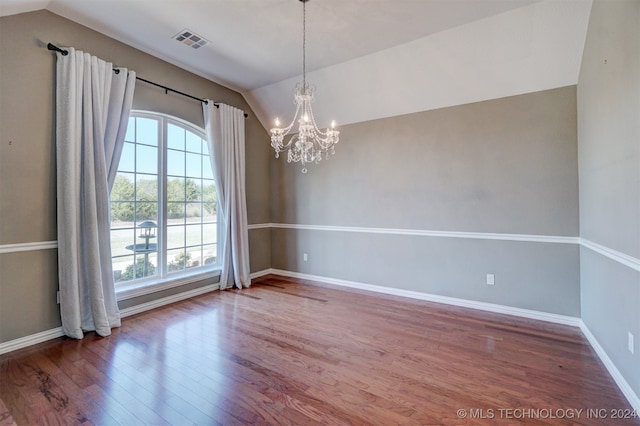 unfurnished dining area featuring hardwood / wood-style floors, vaulted ceiling, and a chandelier