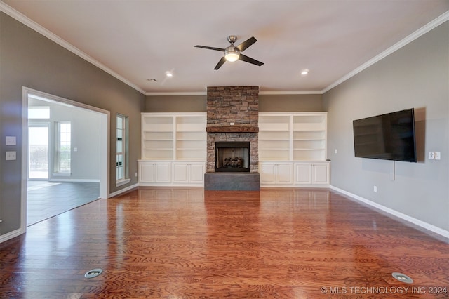 unfurnished living room with ornamental molding, a stone fireplace, and wood-type flooring