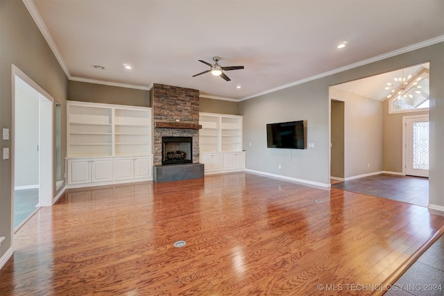 unfurnished living room featuring crown molding, a fireplace, wood-type flooring, and ceiling fan with notable chandelier