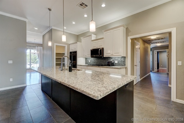 kitchen featuring a large island, light stone countertops, and hanging light fixtures