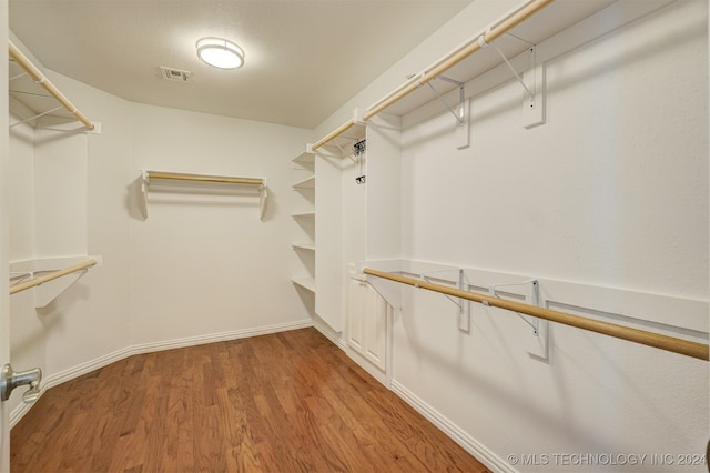 walk in closet with hardwood / wood-style floors