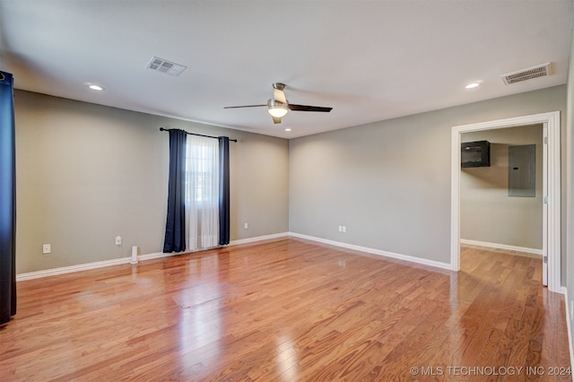 spare room featuring ceiling fan, electric panel, and light hardwood / wood-style flooring