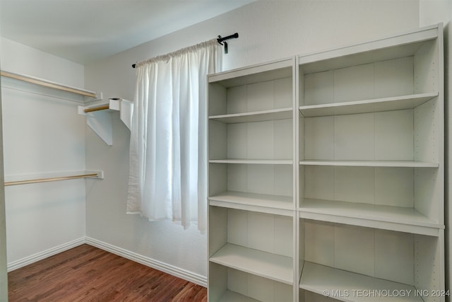 spacious closet featuring dark hardwood / wood-style flooring