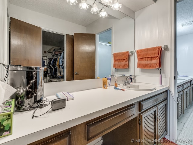 bathroom featuring vanity, a textured ceiling, and tile patterned flooring