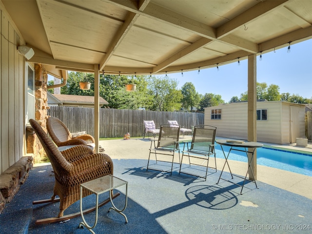 view of swimming pool with a storage unit and a patio