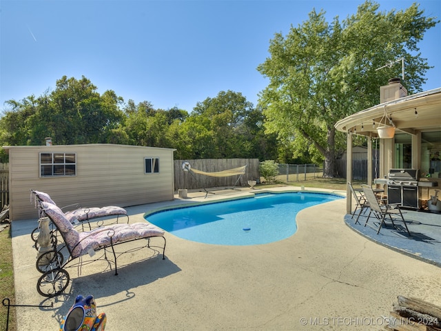 view of pool featuring a patio and a grill