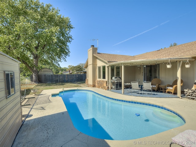 view of swimming pool with a patio and a grill