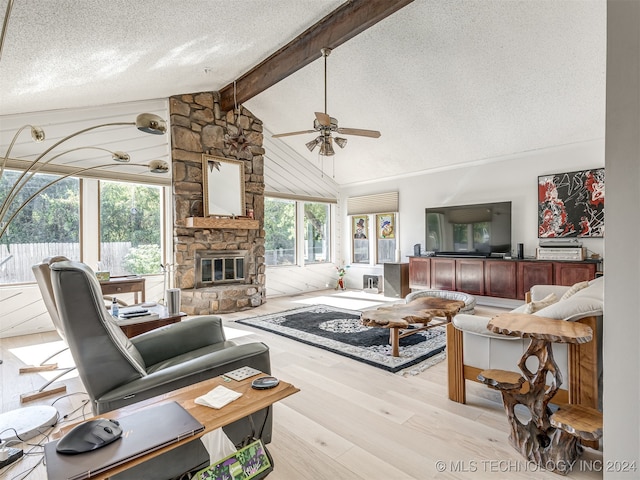 living room with beam ceiling, a textured ceiling, light hardwood / wood-style floors, and plenty of natural light